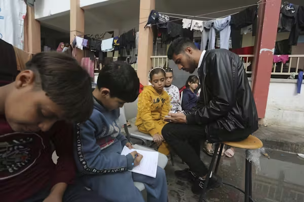 Teacher Tariq Al-Annabi holds class in an outdoor UN-run school during a temporary ceasefire.
